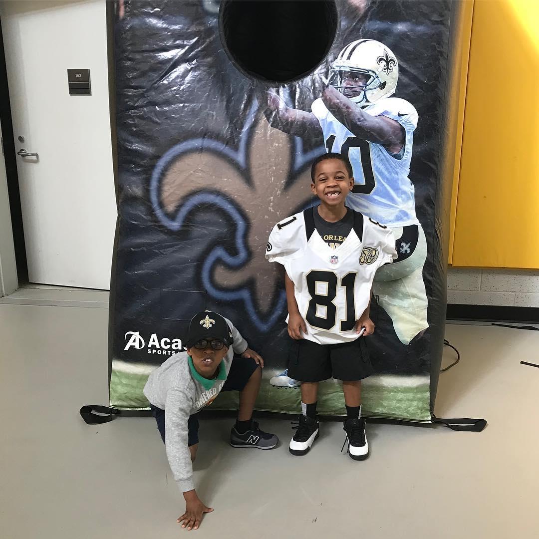 Two KECP students pose by a Saints poster